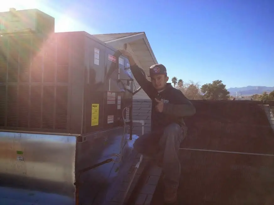 HVAC technician performing AC Tune-Up on a rooftop unit in Avon Lake